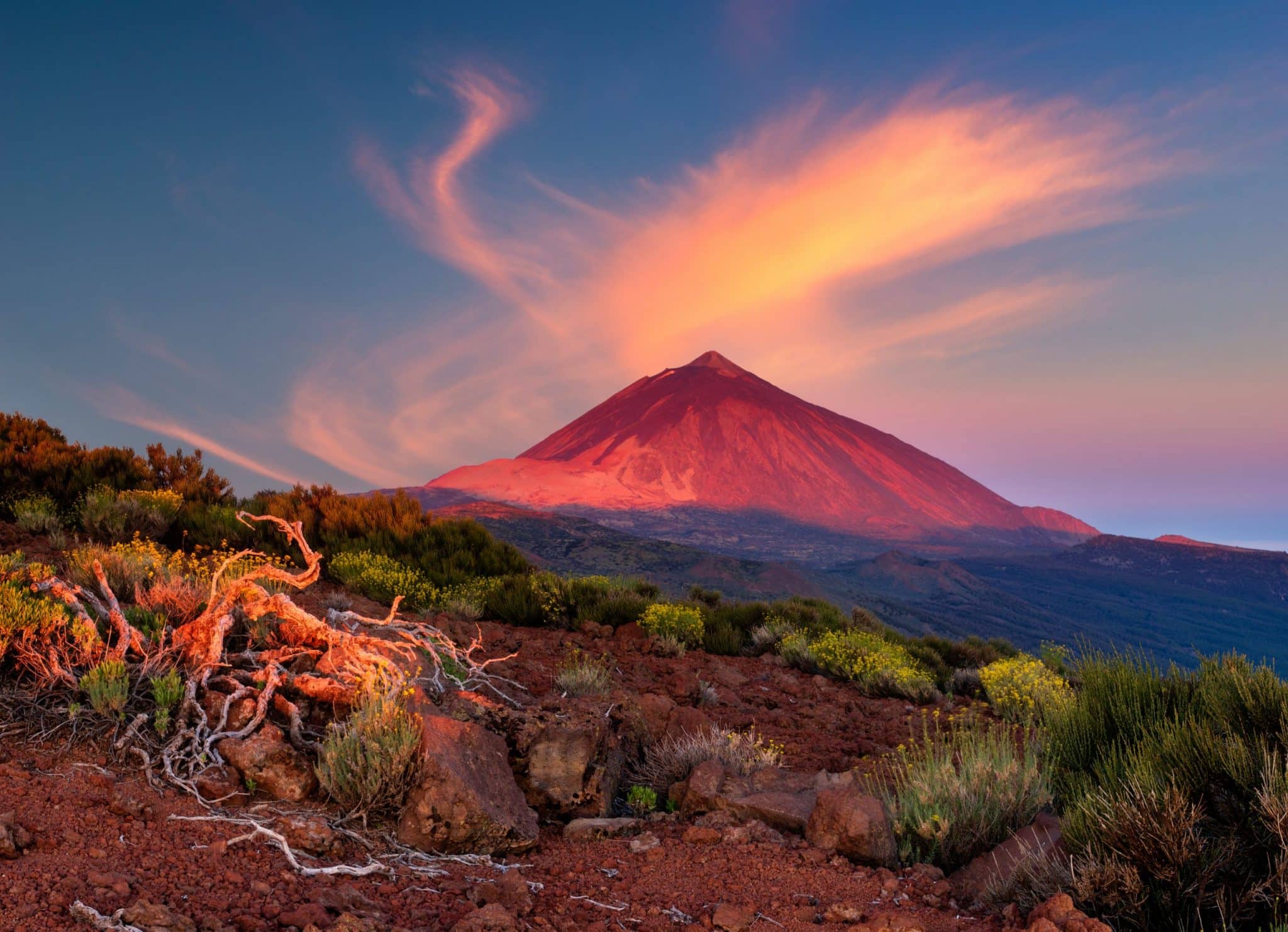 Vulkan Teide auf Teneriffa im Licht der aufgehenden Sonne mit rötlicher Landschaft