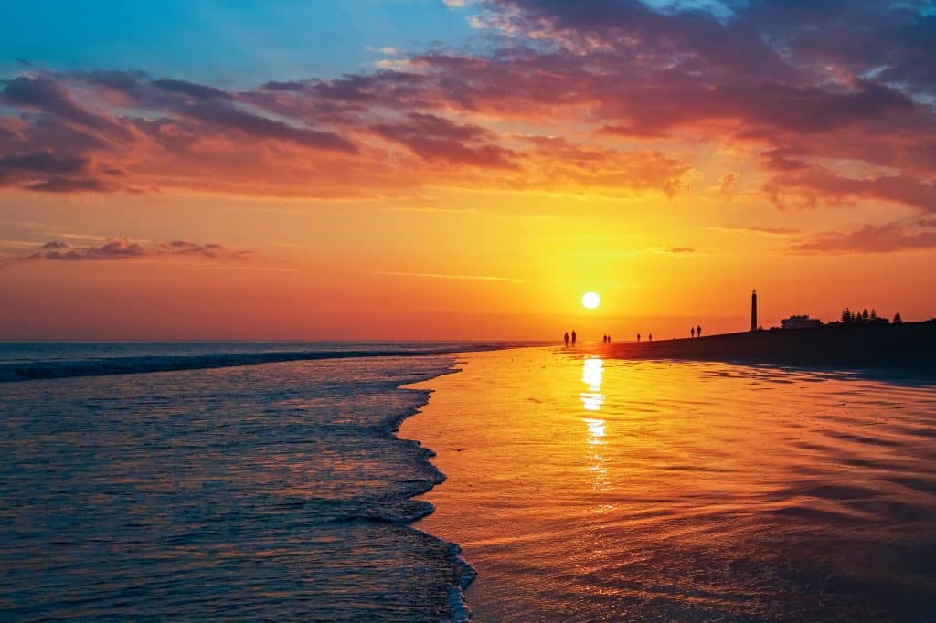 Sonnenuntergang am Strand von Maspalomas auf Gran Canaria mit Leuchtturm im Hintergrund