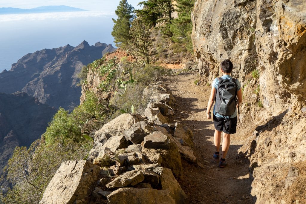 Wanderer auf einem Höhenweg auf La Gomera mit Blick auf Atlantik und Gebirge